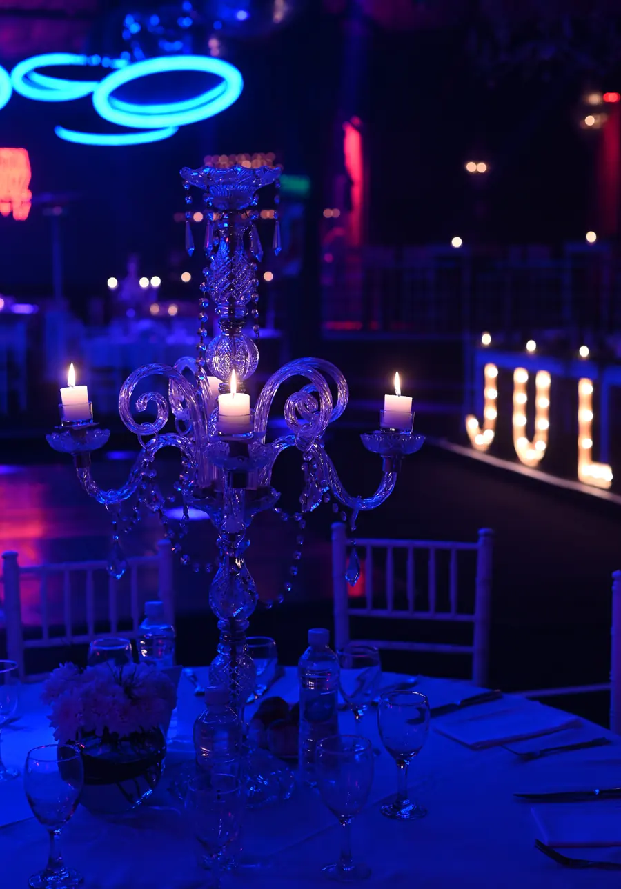 Mesa con candelabros de cristal y letras luminosas